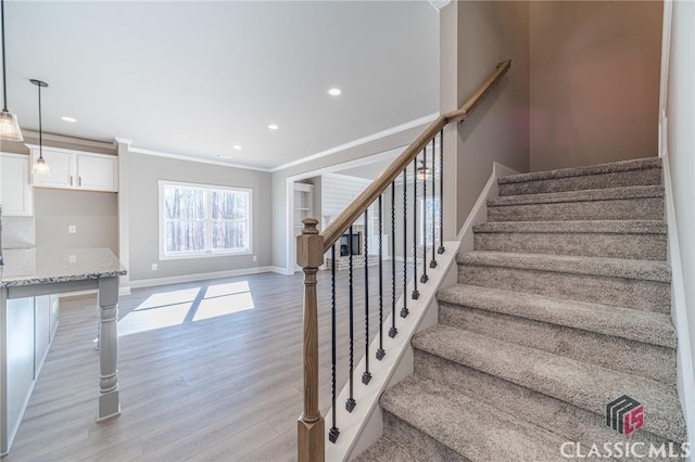 stairway with hardwood / wood-style flooring and crown molding