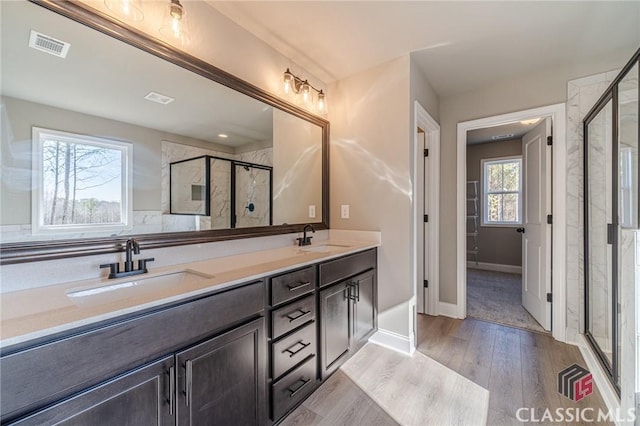 bathroom featuring hardwood / wood-style floors, an enclosed shower, and vanity