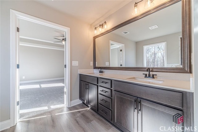 bathroom featuring ceiling fan, wood-type flooring, and vanity