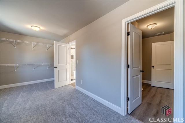 unfurnished bedroom with a closet and dark colored carpet