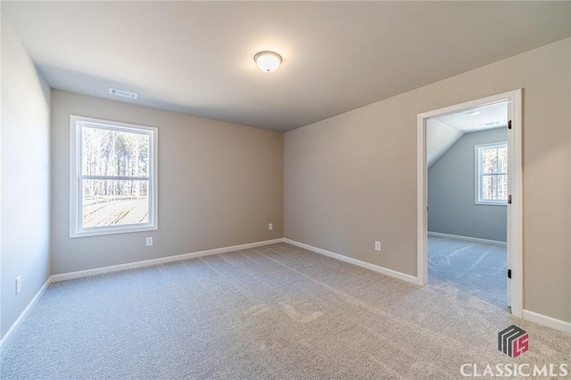 empty room with light carpet and vaulted ceiling