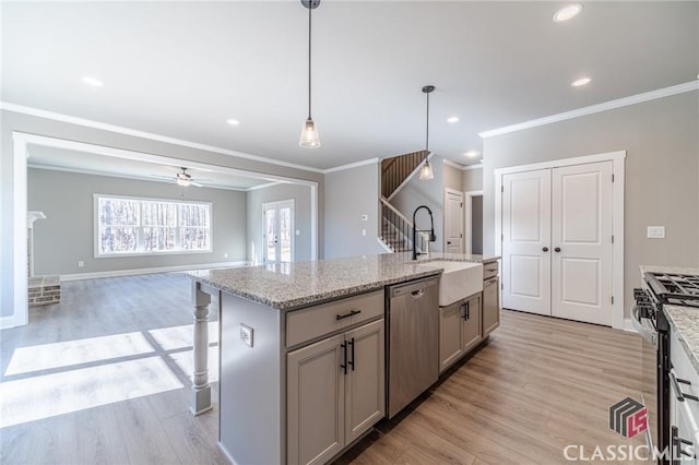 kitchen with gray cabinets, an island with sink, appliances with stainless steel finishes, pendant lighting, and sink