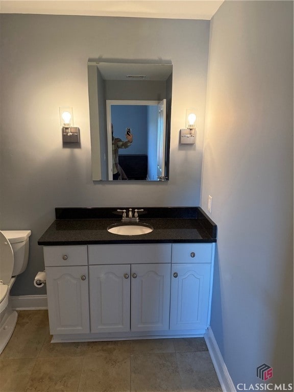 bathroom with tile patterned floors, vanity, and toilet