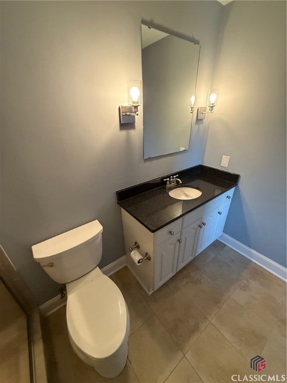 bathroom with tile patterned flooring, vanity, and toilet