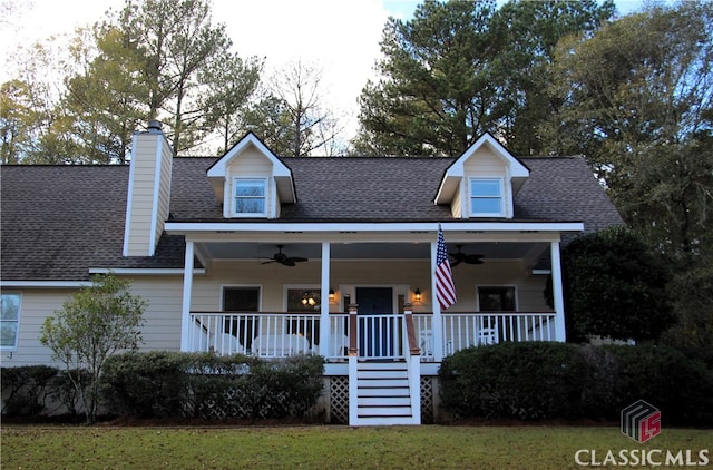 cape cod-style house featuring covered porch and a front lawn