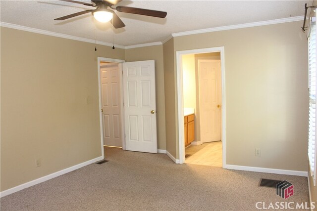 unfurnished bedroom with baseboards, ornamental molding, visible vents, and light colored carpet