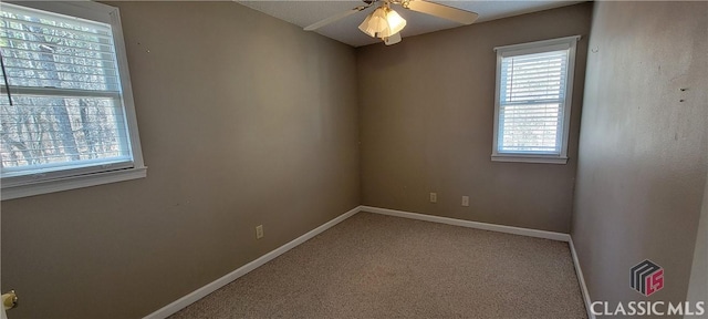 unfurnished room featuring a ceiling fan, light colored carpet, and baseboards