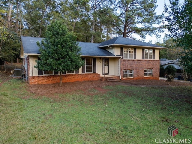 split level home featuring cooling unit and a front lawn