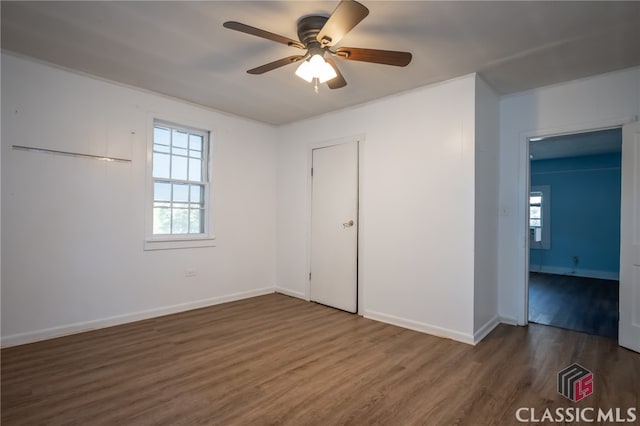 unfurnished bedroom featuring ceiling fan and dark hardwood / wood-style flooring