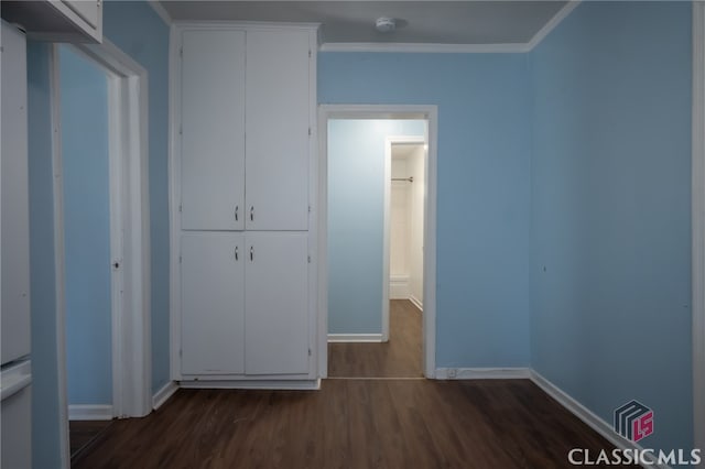 unfurnished bedroom featuring dark hardwood / wood-style flooring, a closet, and ornamental molding