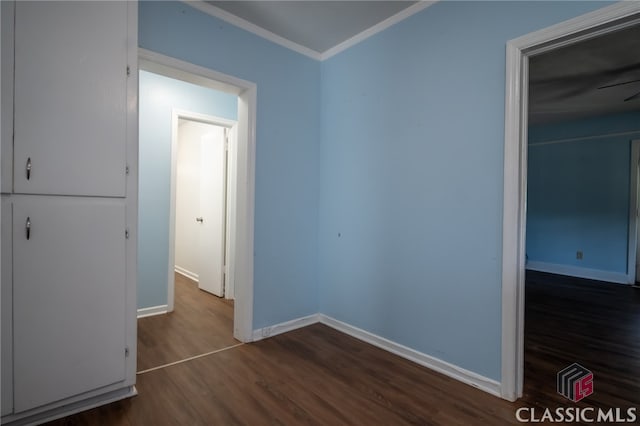 empty room with ceiling fan, dark hardwood / wood-style flooring, and ornamental molding