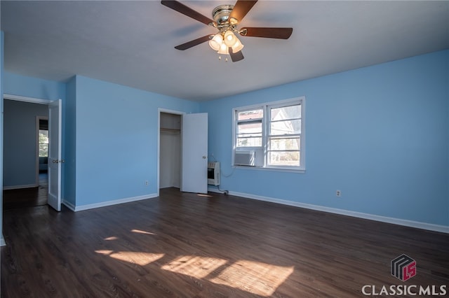 unfurnished room with heating unit, dark hardwood / wood-style floors, and ceiling fan