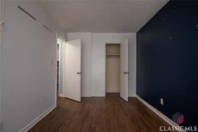 unfurnished bedroom with dark hardwood / wood-style flooring