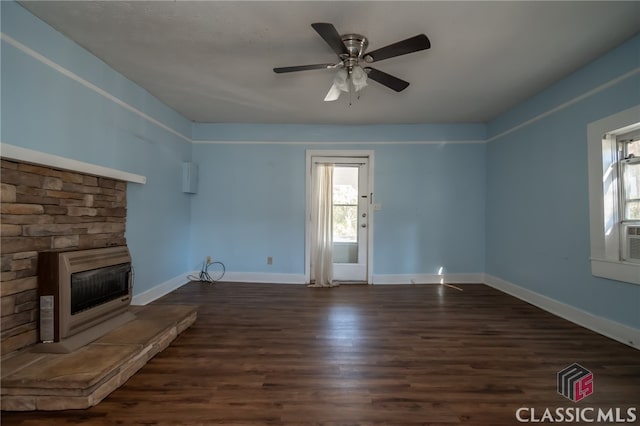 unfurnished living room with dark hardwood / wood-style floors, ceiling fan, a fireplace, and heating unit