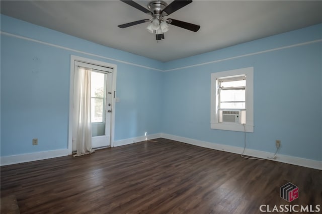 empty room featuring dark hardwood / wood-style floors, ceiling fan, a wealth of natural light, and cooling unit