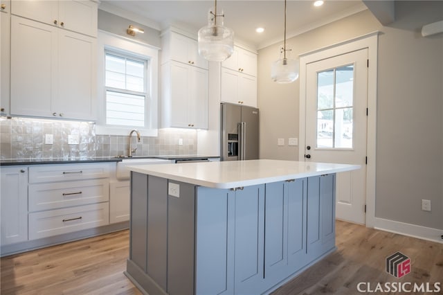 kitchen with white cabinets, pendant lighting, high end fridge, and a healthy amount of sunlight