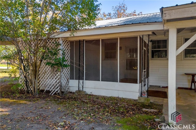 view of property exterior with a sunroom