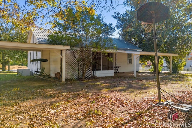 back of property with a carport and central AC