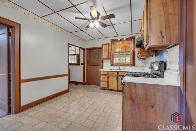 kitchen with ceiling fan, sink, and stainless steel stove