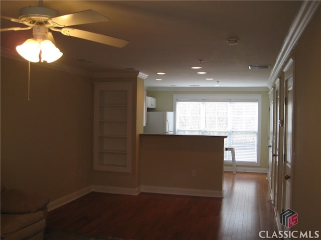 unfurnished living room featuring ceiling fan, crown molding, and dark wood-type flooring