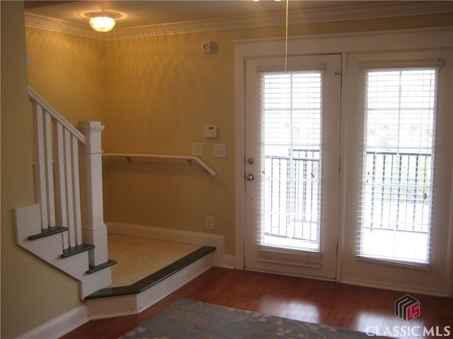 doorway to outside with crown molding and dark wood-type flooring