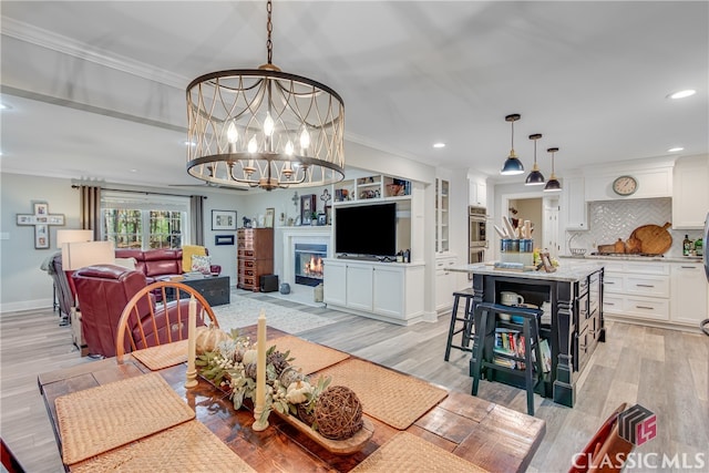 dining space with a chandelier, crown molding, and light hardwood / wood-style flooring