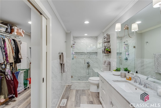 bathroom with walk in shower, ornamental molding, vanity, hardwood / wood-style floors, and toilet