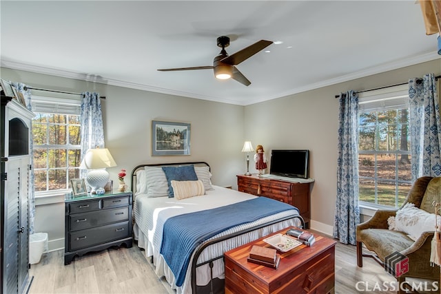 bedroom featuring ceiling fan, light hardwood / wood-style floors, and multiple windows