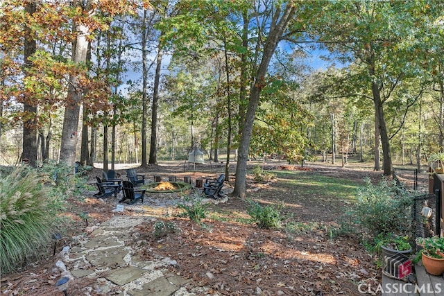 view of yard featuring a trampoline and an outdoor fire pit