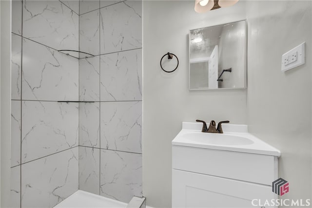 bathroom featuring a tile shower and vanity