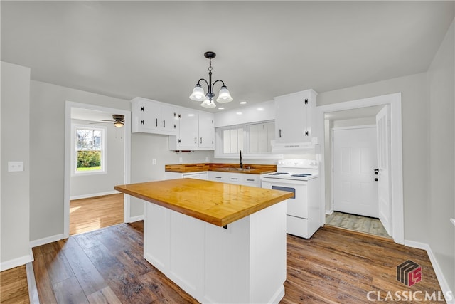 kitchen featuring pendant lighting, dark wood-type flooring, white cabinets, electric stove, and sink