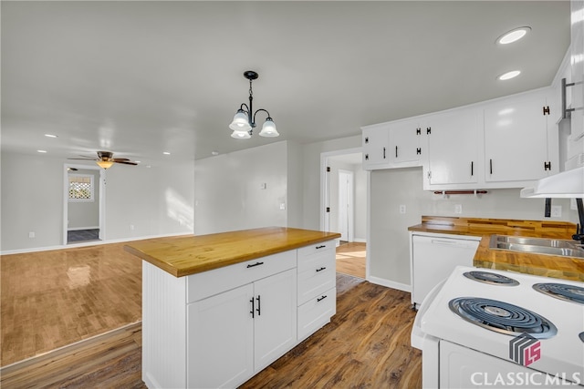 kitchen featuring white appliances, decorative light fixtures, hardwood / wood-style flooring, white cabinetry, and butcher block counters