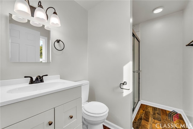 bathroom with toilet, an enclosed shower, wood-type flooring, and vanity