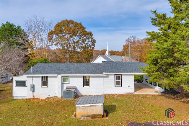 back of property featuring a yard and central AC