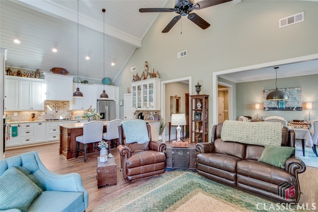 living room with light wood-type flooring, high vaulted ceiling, and ceiling fan