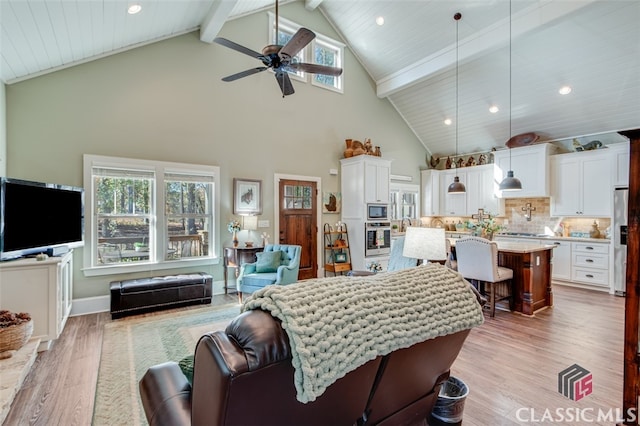 living room with beamed ceiling, light wood-type flooring, high vaulted ceiling, and ceiling fan