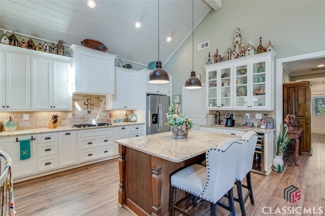 kitchen with white cabinetry, high vaulted ceiling, backsplash, pendant lighting, and appliances with stainless steel finishes