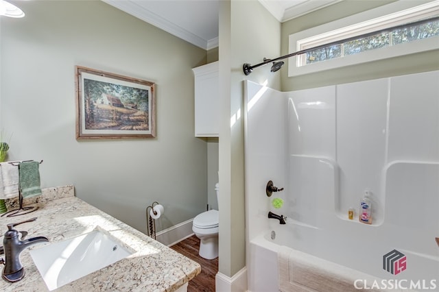 full bathroom with vanity, washtub / shower combination, hardwood / wood-style flooring, toilet, and ornamental molding