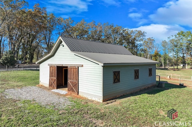 view of side of property with an outbuilding and a yard