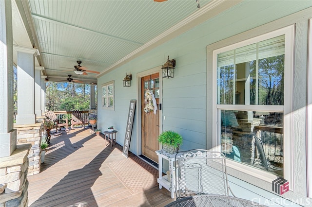 wooden terrace with ceiling fan and a porch