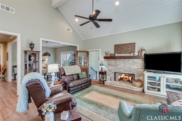 living room featuring ceiling fan, a fireplace, high vaulted ceiling, and wood-type flooring