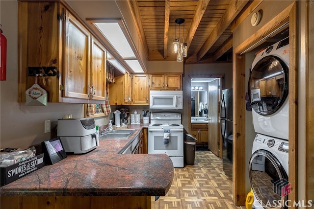 kitchen with kitchen peninsula, white appliances, sink, beam ceiling, and stacked washer / drying machine