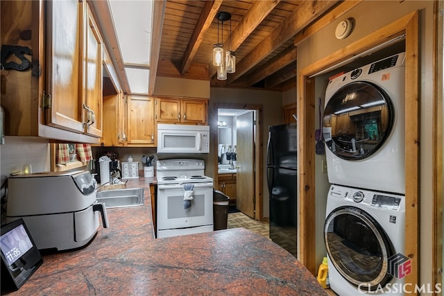 kitchen featuring white appliances, sink, beam ceiling, pendant lighting, and stacked washer / dryer