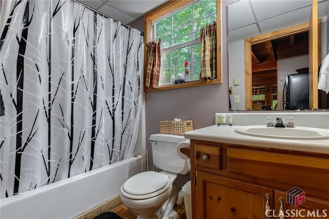 full bathroom with a drop ceiling, toilet, vanity, and shower / tub combo