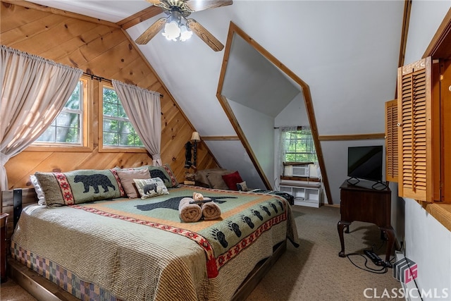 bedroom featuring wood walls, multiple windows, lofted ceiling, and ceiling fan