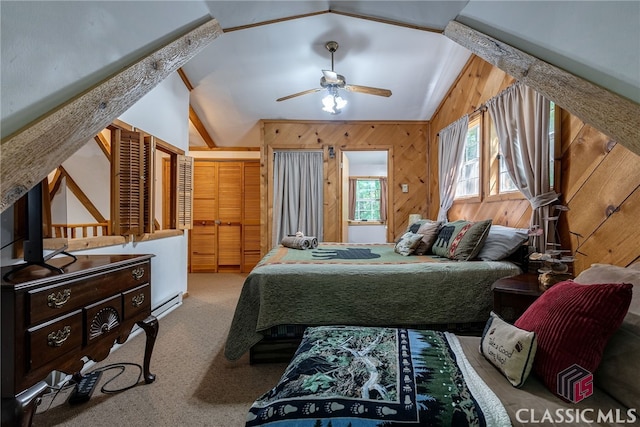 bedroom with ceiling fan, carpet floors, wooden walls, and vaulted ceiling