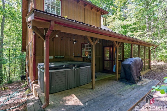 deck with grilling area and a hot tub