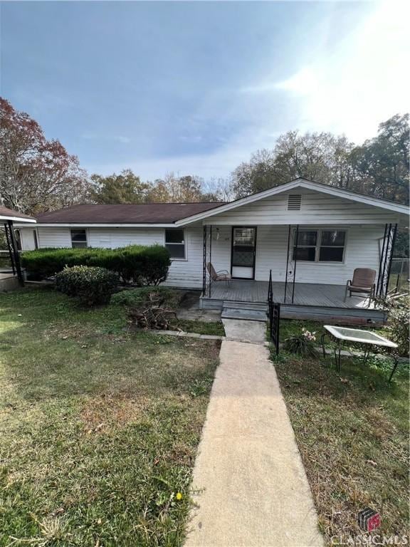 view of front of property featuring covered porch and a front lawn