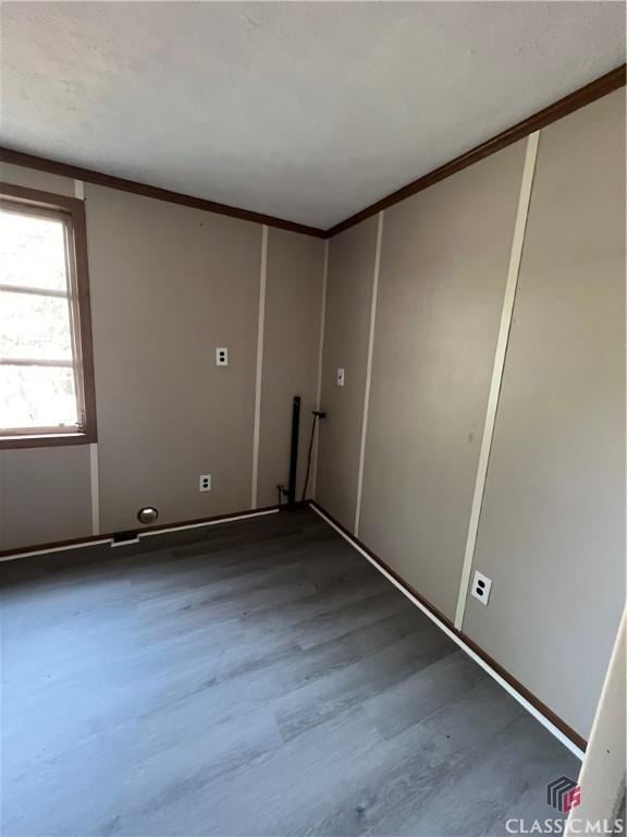 unfurnished room featuring crown molding and hardwood / wood-style flooring