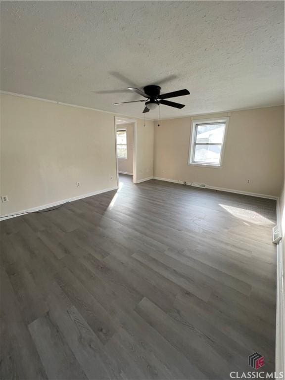 spare room with a textured ceiling, ceiling fan, and dark hardwood / wood-style floors